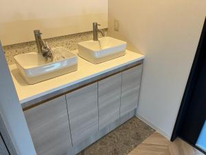 two sinks on a counter in a bathroom at Business Hotel Legato in Tokyo