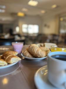 two plates of croissants and a cup of coffee on a table at Hotel Confianza I in Corrientes