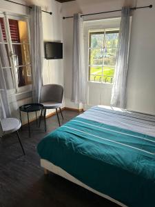 Ferrette的住宿－Chambres d'Hôtes Le Felseneck - NOUVEAU PROPRIÉTAIRE - NEW MANAGEMENT，卧室配有床、椅子和窗户。