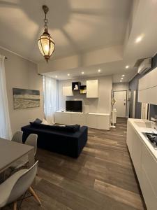 ein Wohnzimmer mit einem schwarzen Sofa und einer Küche in der Unterkunft Nuovo Appartamento Borgo Coscia in Alassio