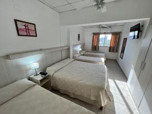 a hotel room with two beds and two windows at Hotel Confianza I in Corrientes
