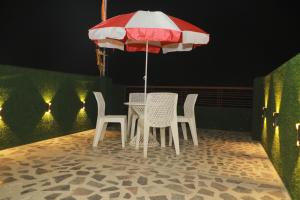 a table and chairs under an umbrella on a patio at De Classico Hotel in Varanasi