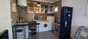 małą kuchnię z pralką i suszarką w obiekcie Studio face verdure w mieście Montreuil