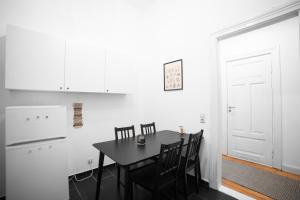 a dining room with a black table and chairs at Altbauoase im Goethequartier in Bremerhaven