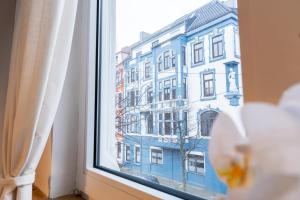 a window with a view of a blue building at Altbauoase im Goethequartier in Bremerhaven