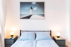 um quarto com uma cama com uma fotografia de um farol em Altbauoase im Goethequartier em Bremerhaven