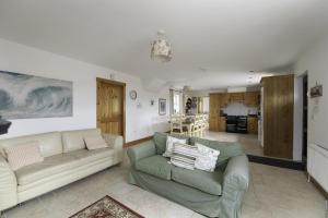 a living room with two couches and a kitchen at Rhea Holiday Home Bantry in Bantry