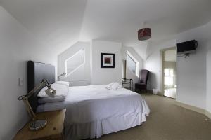 a bedroom with a white bed and a desk with a lamp at Rhea Holiday Home Bantry in Bantry