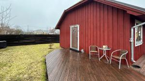 a red building with a table and chairs on a deck at Villa Aili in Pärnu