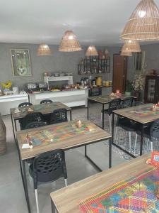una habitación con mesas y sillas y una cocina en Pousada Villa Minduba, en Japaratinga