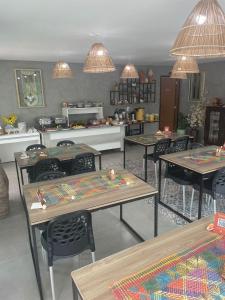 a room with tables and chairs and a kitchen at Pousada Villa Minduba in Japaratinga