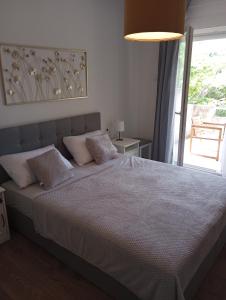 a bedroom with a large bed with a large window at Apartmani Marina in Rab