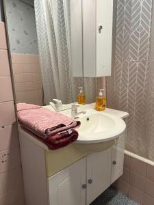 een badkamer met een witte wastafel en een spiegel bij Blue Appartement in Sint-Niklaas