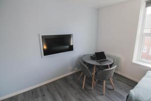 Habitación pequeña con mesa y ordenador portátil. en Beautiful 1 Bedroom Central Flat en Leamington Spa