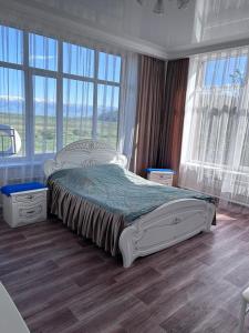 - une chambre avec un grand lit et de grandes fenêtres dans l'établissement California, 