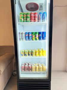 an open refrigerator filled with soda cans and sodas at Shangg INN in Ipoh
