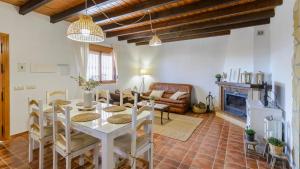 een woonkamer met een tafel en een open haard bij Casa Los Limones El Borge by Ruralidays in Borge