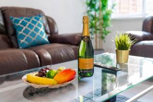 a bottle of wine and a bowl of fruit on a table at Large 5 Bedroom Edgbaston Townhouse - 10 Guests - Free WIFI, Netflix & On street Parking - 974P in Birmingham
