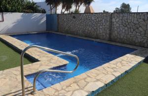 コニル・デ・ラ・フロンテーラにあるApartamento en Conil con piscinaの裏庭のラップスイミングプール(手すり付)