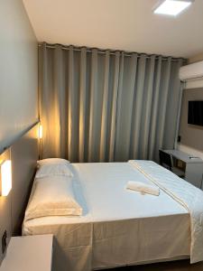 ein Schlafzimmer mit einem Bett vor einem Vorhang in der Unterkunft Hotel Giacomin in Dois Lajeados + 63 Fotos