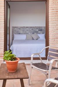 Argés的住宿－Casas rurales El Aljibe, lavanda，一间卧室,在庭院里配有一张床和一把椅子