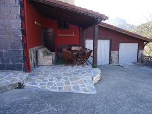 a patio with a table and chairs next to a building at La Coruxa in Los Cabos