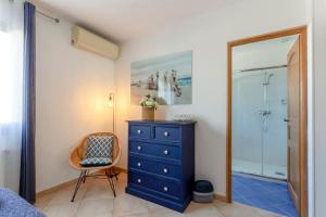 Schlafzimmer mit blauer Kommode und Glasdusche in der Unterkunft Chez Céline - Superbe Villa climatisée avec 4 chambres indépendantes et piscine privée in Le Grau-du-Roi