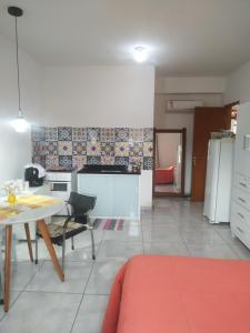 Flat 302 في Ubá: غرفة معيشة مع طاولة ومطبخ