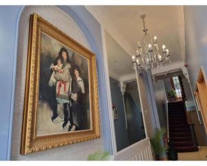a painting of a family hanging on a wall at F405-Comfy Studio for 1 near Hyde Park in London