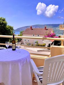 a bottle of wine sitting on a table with chairs at Sunshine house in Herceg-Novi