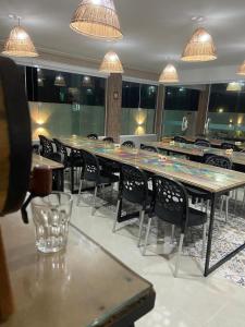 une salle à manger avec des tables, des chaises et des lumières dans l'établissement Pousada Villa Minduba, à Japaratinga