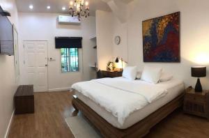 een slaapkamer met een bed en een schilderij aan de muur bij Rimklong boutique hotel trad in Trat