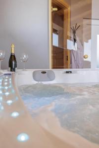 a bath tub with a bottle of wine and two wine glasses at Villa Canolle in Jastrebarsko