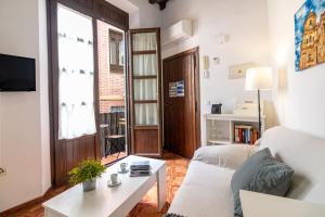 a living room with a white couch and a table at Granada FreshApartments by Bossh! Apartments in M&aacute;laga