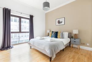 a bedroom with a bed and a large window at The Clerkenwell Flat in Greenford