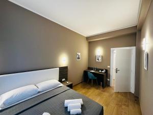a bedroom with a bed and a desk in it at Sunset Guest House in Reggio di Calabria