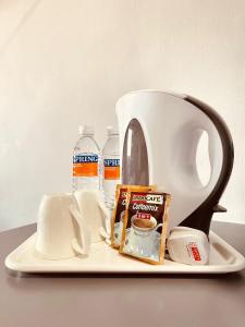 a tea pot and two bottles of water on a plate at Penview Hotel in Kuching