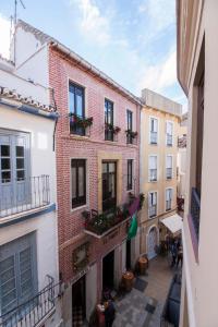 un callejón en un edificio antiguo con flores en los balcones en Granada FreshApartments by Bossh! Apartments, en Málaga