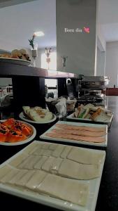 una línea de buffet con diferentes tipos de comida en platos en Monte Líbano II, en Florianópolis