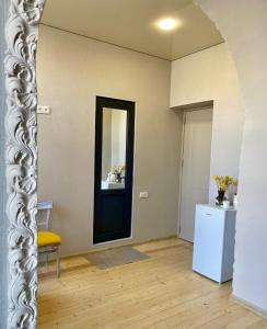 a room with a black door and a yellow chair at Moedani-Very Center Apartments in Kutaisi in Kutaisi