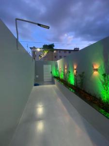 a row of green lights on a wall at Porto Residence in Vitória da Conquista