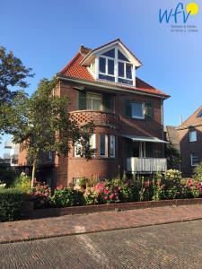 a brick house with flowers in front of it at Haus Colonia - Wohnung 3 in Wangerooge