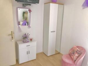 een kamer met een roze stoel en een spiegel bij Villa Marga in Jelsa