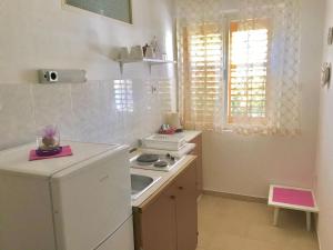 a small kitchen with a stove and a sink at Villa Marga in Jelsa