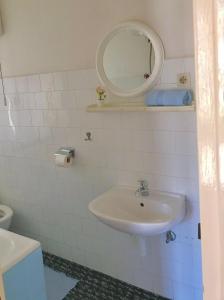 a white bathroom with a sink and a mirror at Villa Marga in Jelsa