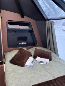 a bed with two towels and two water bottles on it at AuroraHut at Sauna Retreat in Rovaniemi +39 photos