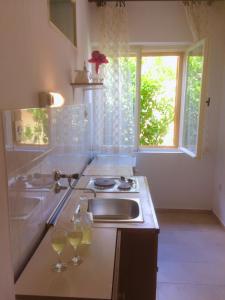 een keuken met een wastafel en 2 glazen wijn bij Villa Marga in Jelsa
