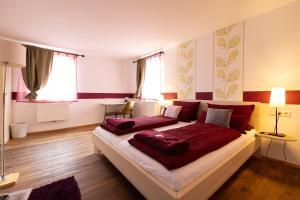 Hotel DAH-Inn في داخاو: غرفة نوم بسرير كبير مع شراشف حمراء
