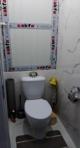 uma casa de banho com um WC branco e um espelho. em Chilanzar-21, Tashkent em Tashkent