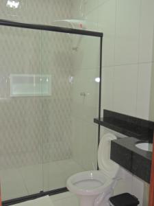 a bathroom with a toilet and a glass shower at Porto Residence in Vitória da Conquista +18 photos